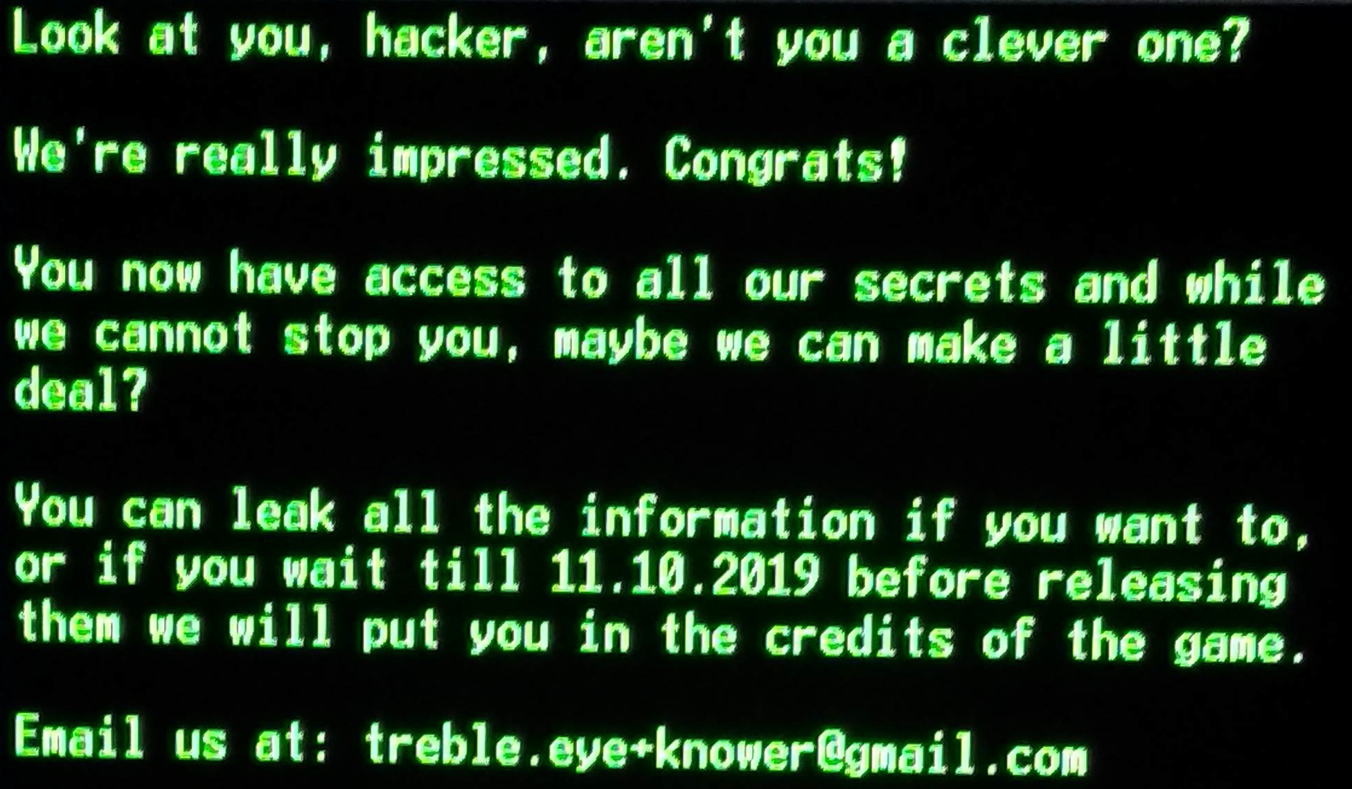 Green text with a black background.
The text is: "Look at you, hacker, aren't you a clever one? We're really impressed.
Congrats! You now have access to all our secrets and while we cannot stop you,
maybe we can make a little deal? You can leak all the information if you want to.
or if you wait till 11.10.2019 before releasing them we will put you in the credits of the game."
